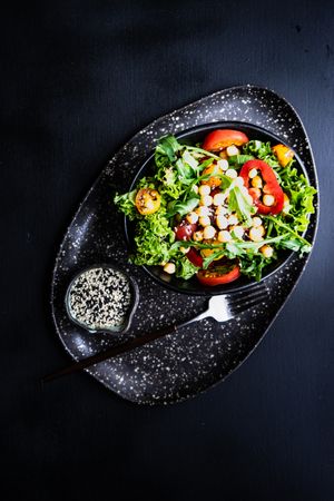 Top view of organic vegetable salad with garbanzo beans and sesame seeds and space for text