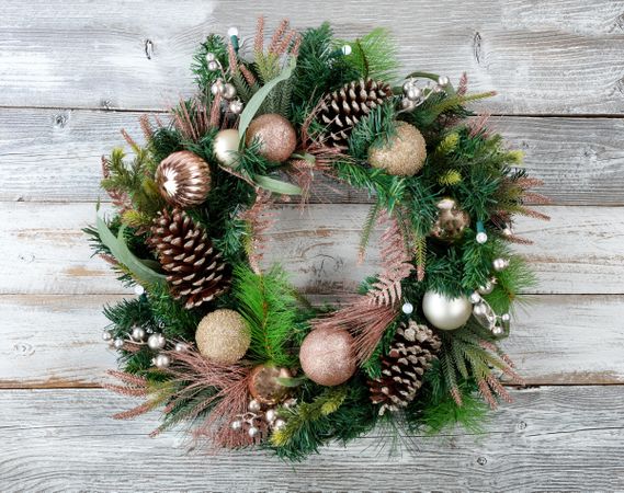 Christmas holiday wreath with illuminated lights on rustic wooden boards