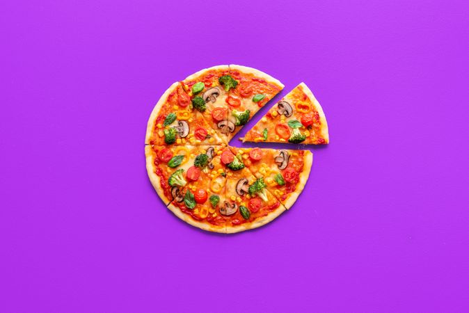 Vegan pizza top view, isolated on a purple background