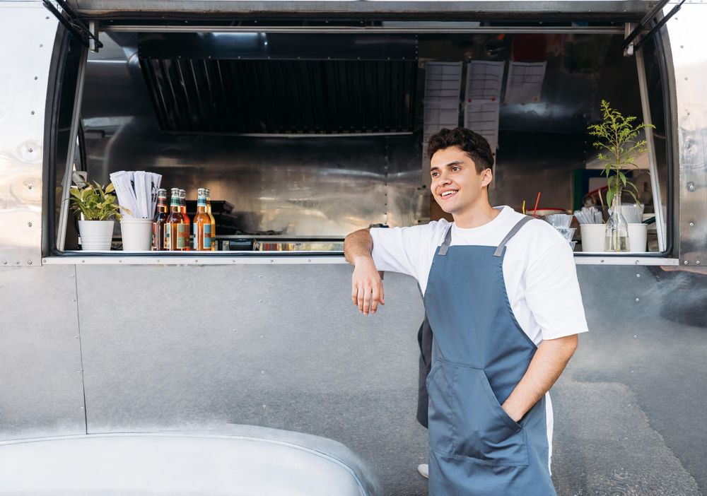 Portrait of a confident entrepreneur leaning in window of his business