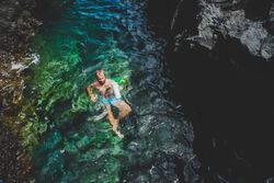 Man swimming in water with rubbish