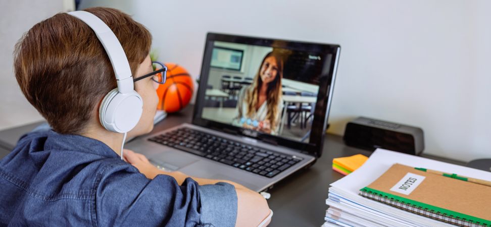 Boy with headphones receiving class at home with laptop from his