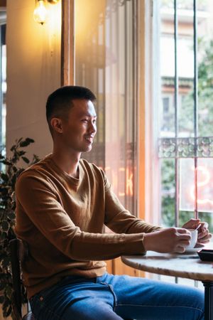 Smiling Asian man in a cafeteria.
