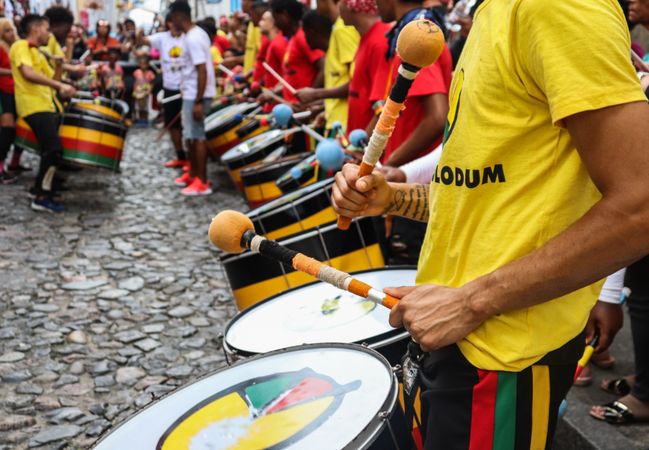 Man in yellow crew neck t-shirt playing drum in carnival
