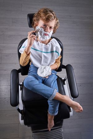 Boy shaving in a barbershop