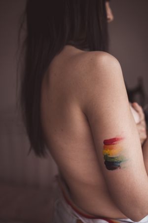 naked woman covering breast and drawing LGBTQIA symbol
