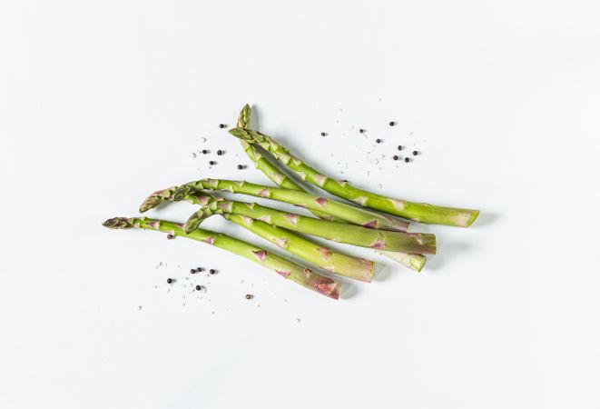 Asparagus with salt and pepper on light background