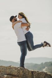Loving couple embracing while standing at mountain cliff
