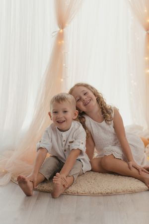 Sister embracing little brother at home