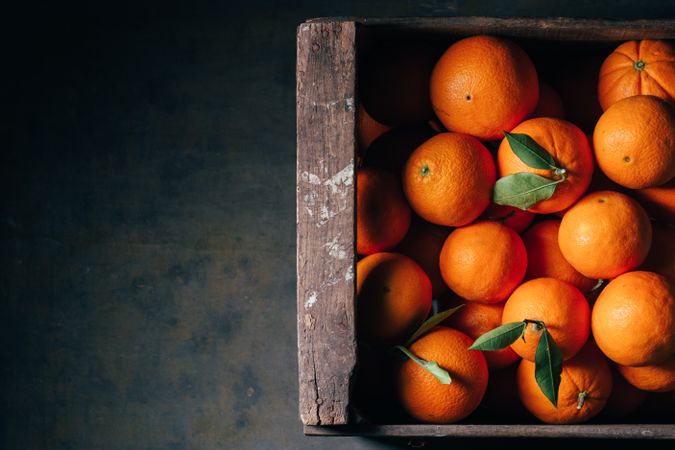 Fresh oranges in an old wooden box