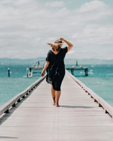 Woman walking on dock on beach