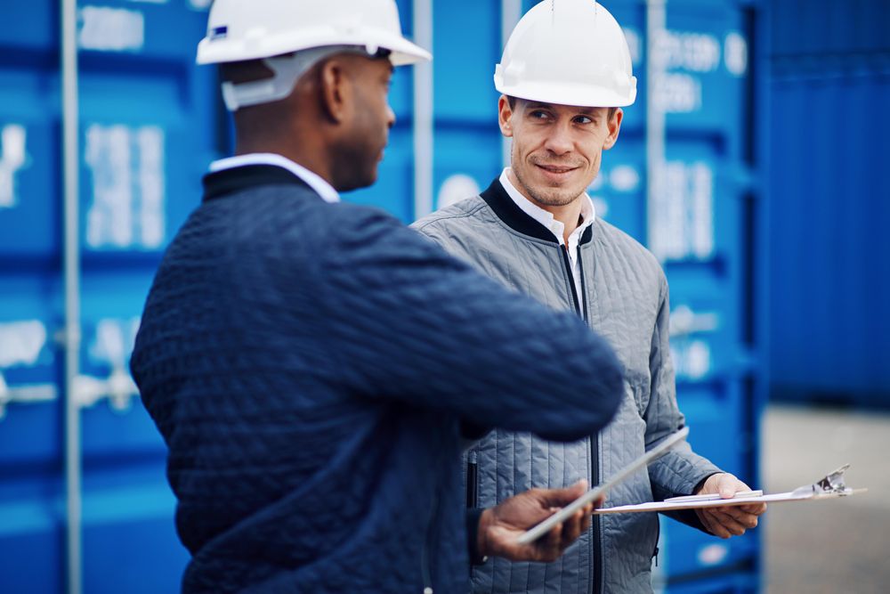 Two men in hardhats discussing a project