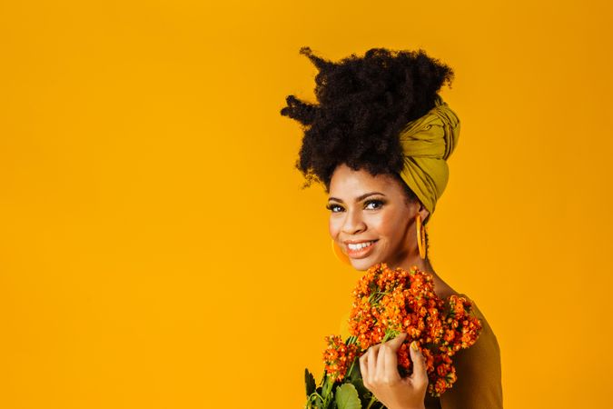 Portrait of Black woman holding orange flowers