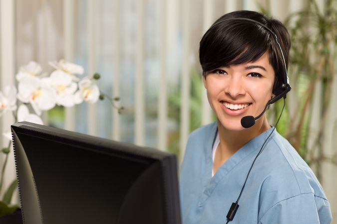 Young Woman Wearing Headset and Scrubs
