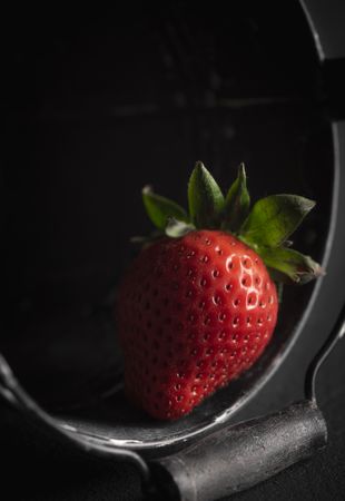 Single strawberry in a bucket