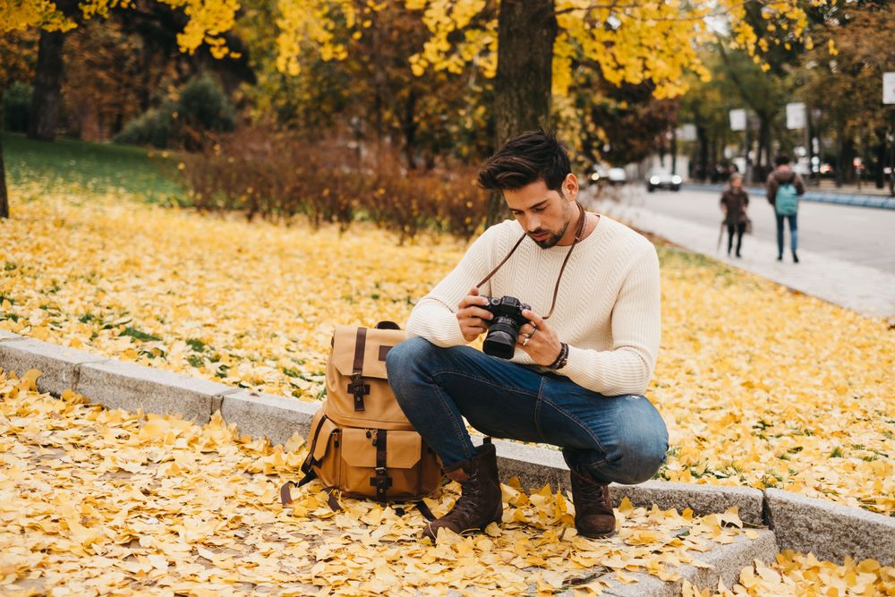 Trendy male with backpack and camera