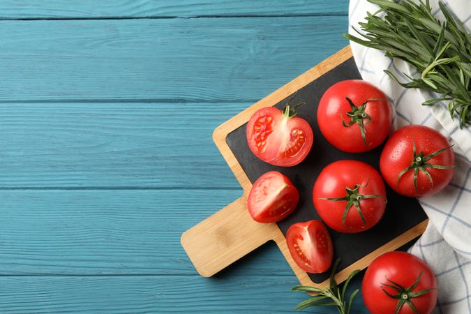 Composition with tomatoes and rosemary on wooden background, top view