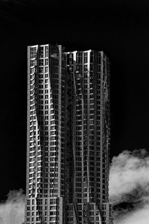 Grayscale photo of brutalist high rise building at night