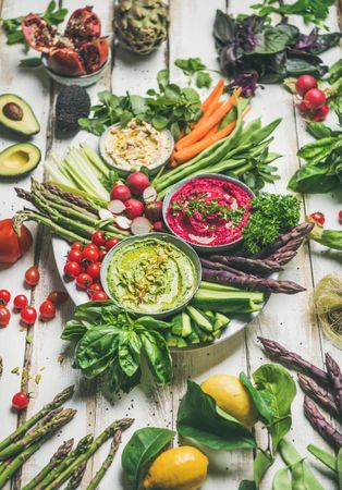 Fresh colorful vegetables and dips with hummus, avocados, asparagus, carrots