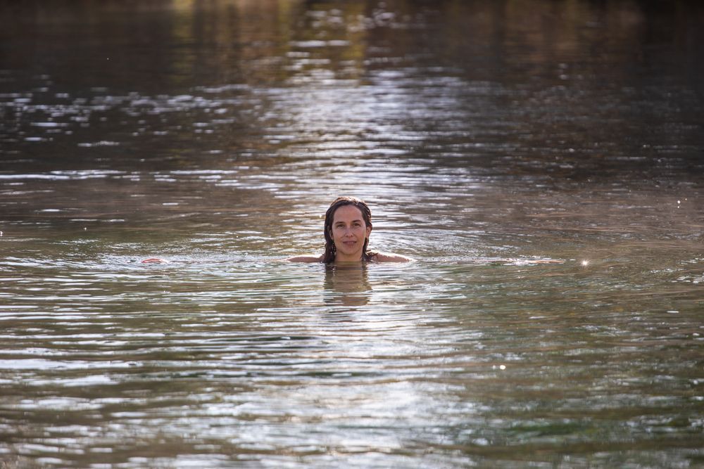 Woman swimming and looking at camera in lake