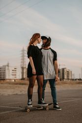Man helping girlfriend to skate on road