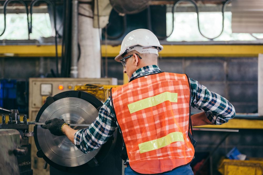 Back view of male metalworker in factory