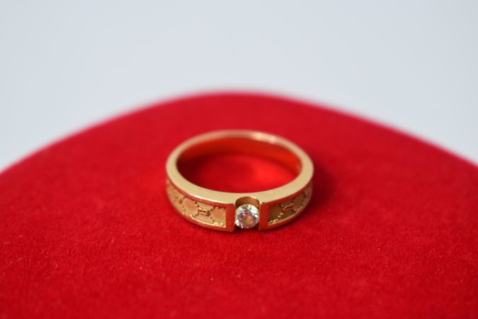 Man's diamond gold ring on red cloth with copy space