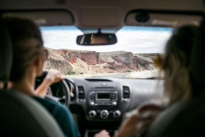 Two women in a car near rocky mountains