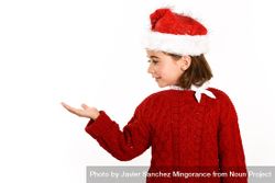 Girl in Christmas outfit with hand presenting copy space 5oJPm0