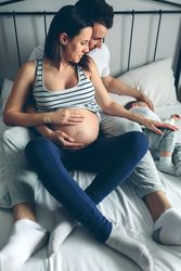 Pregnant woman with her husband looking son