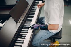 Young man with prosthetic hand playing the piano bGQeB5