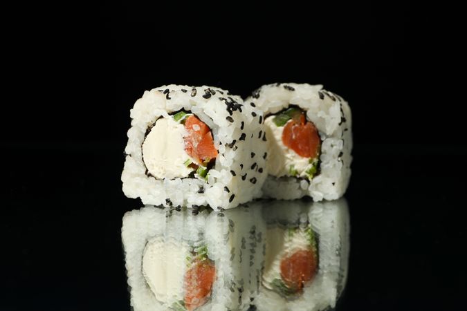 Delicious sushi rolls on dark mirror background. Japanese food