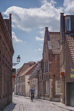 Man riding a bike in an alley in Bruges, Belgium 