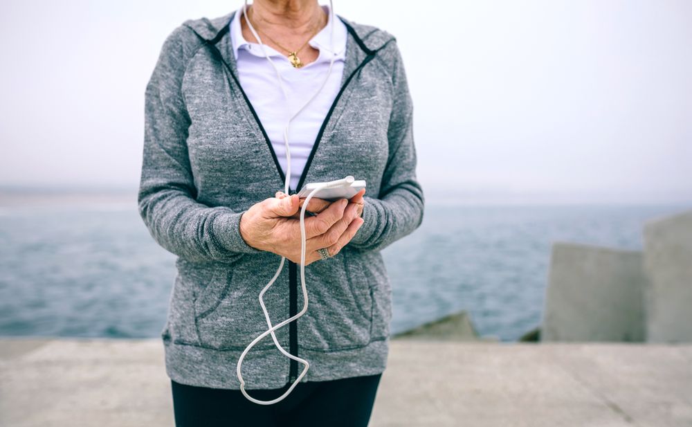 Mature sportswoman holding her smartphone