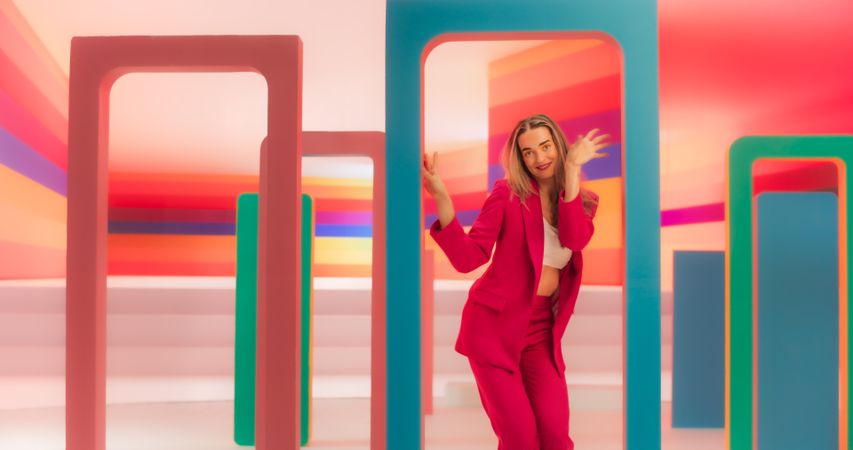 Portrait of Professional Dancer Performing a Routine in Front of a Big Digital Led Wall Screen with Colorful Background in Studio Environment. She is Interacting with Geometric Decoration Prop On Set
