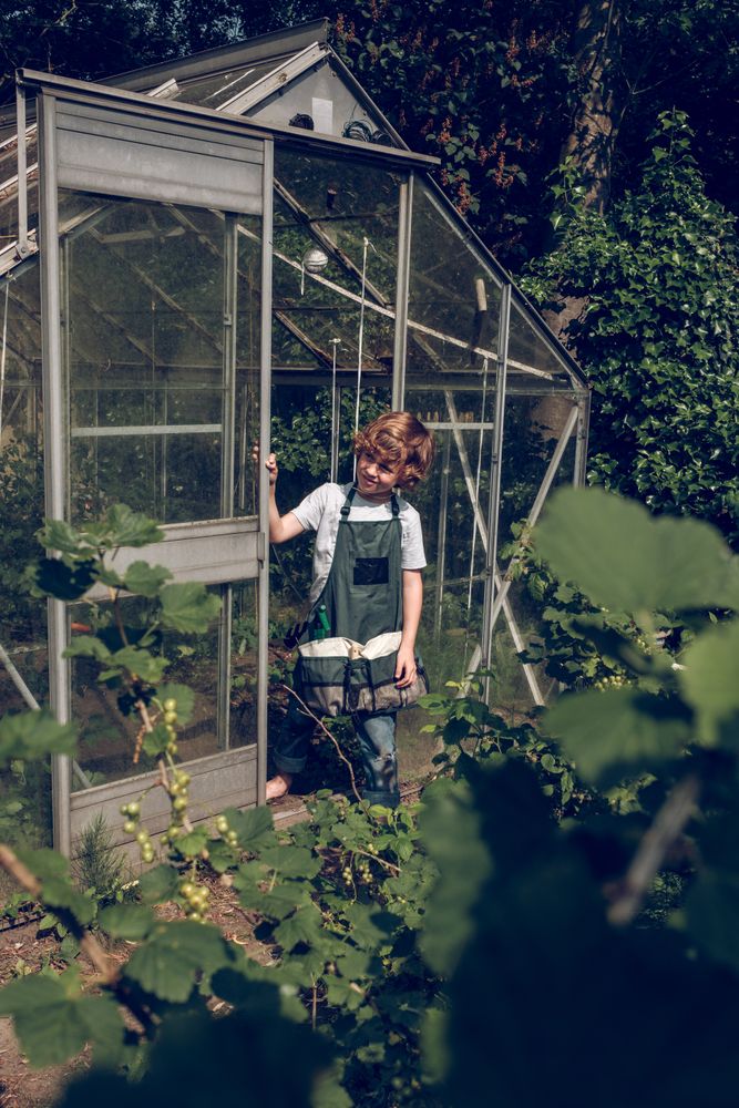Child in apron standing in garden