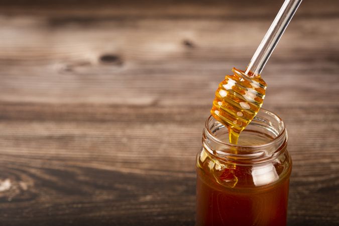 Honey in glass jar on the table.