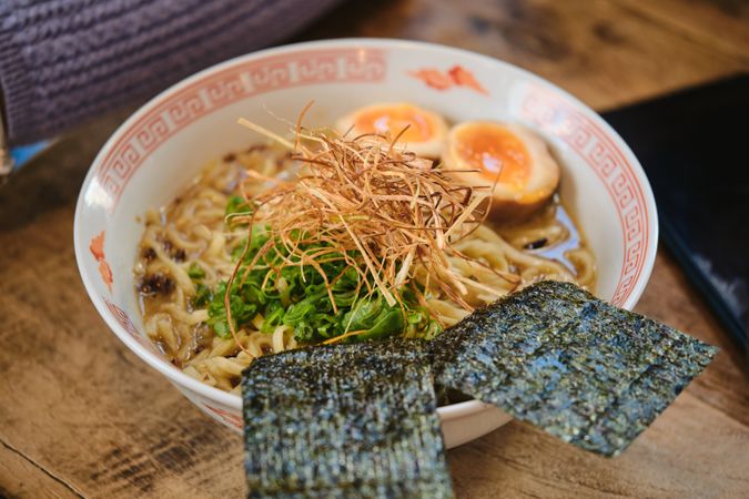 Appetizing bowl of ramen on wooden table