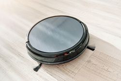 Robotic vacuum cleaner placed on floor in apartment