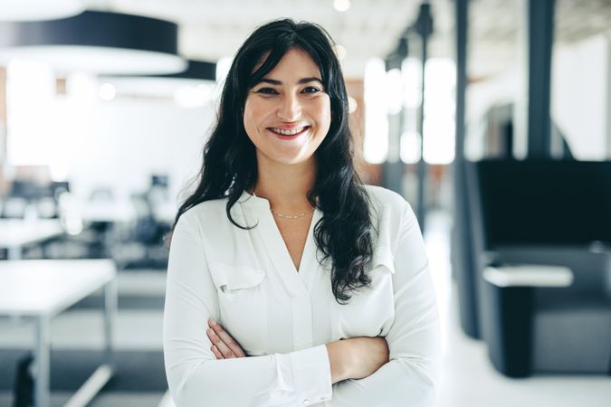 Successful businesswoman smiling at the camera in bright modern office