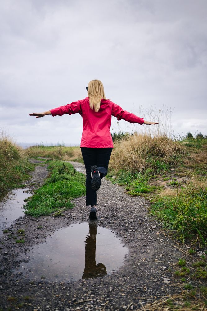 Cheerful woman enjoying countryside landscape stretching hands