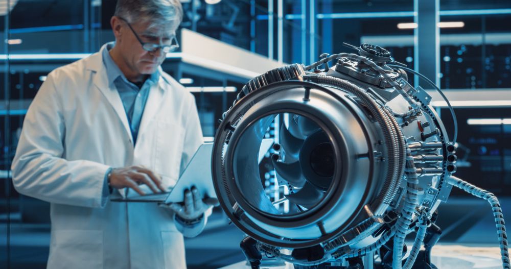 Adult Scientist in Glasses Inspecting a Rotating Fan on an Advanced Turbine Engine.