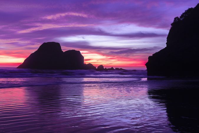 Looking out at scenic view of rocks in the Pacific Ocean at dusk