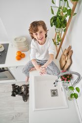 Smiling boy doing hygiene routine in kitchen