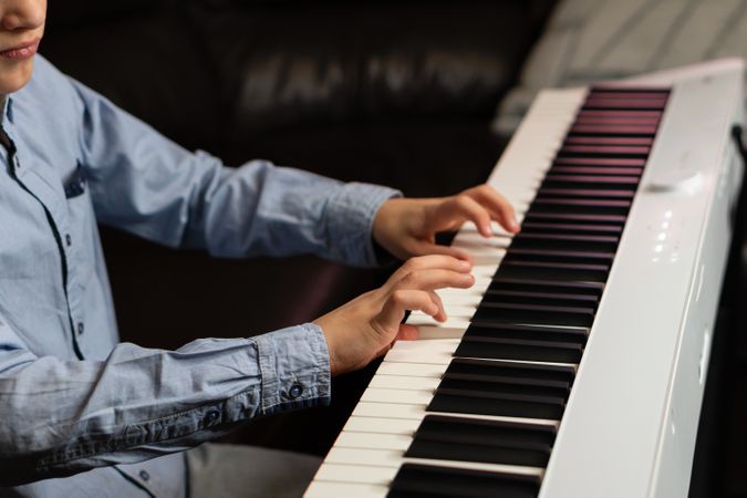 Close-up of boy's hands playing the keyboard.