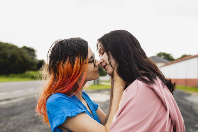 A young lesbian couple kiss outside