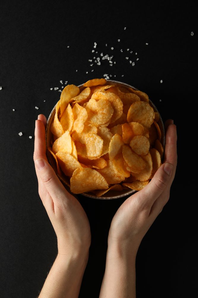 Potato chips in a bowl on a dark background