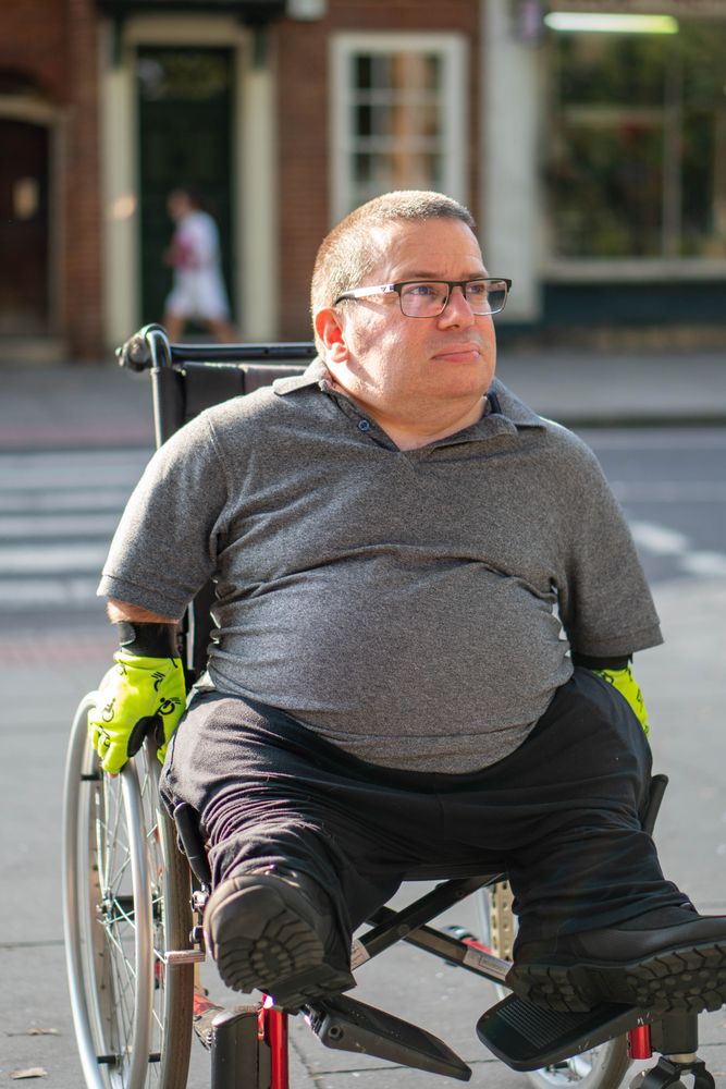 Portrait of man sitting in wheelchair in city street