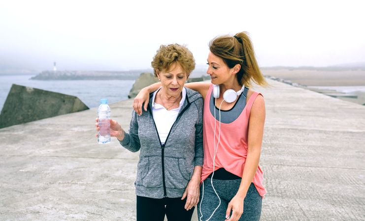 Two women walking by sea pier