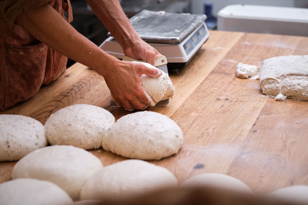 Photo detail of a baker's hands working the bread dough